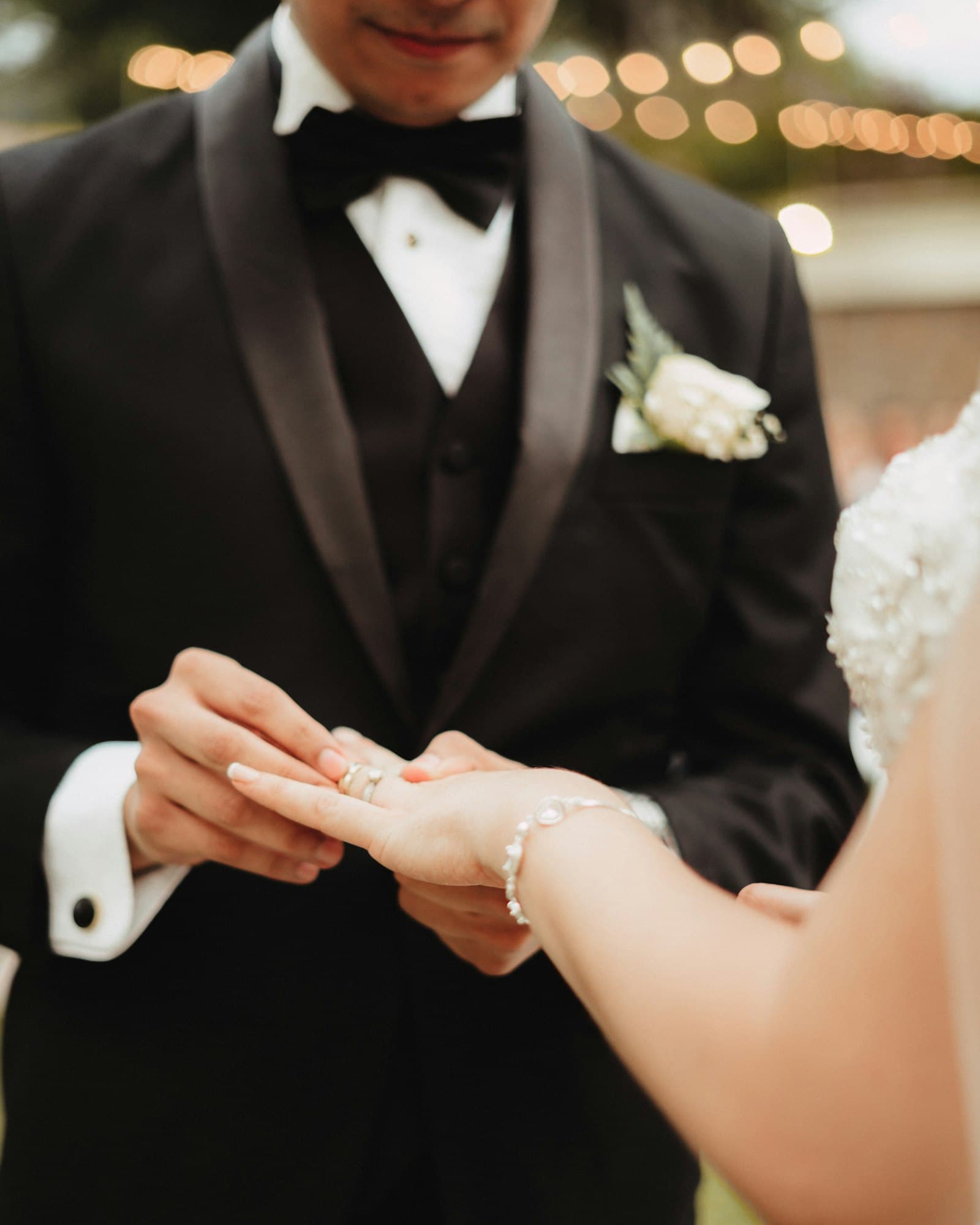 Le marié en smoking glisse l’alliance au doigt de la mariée