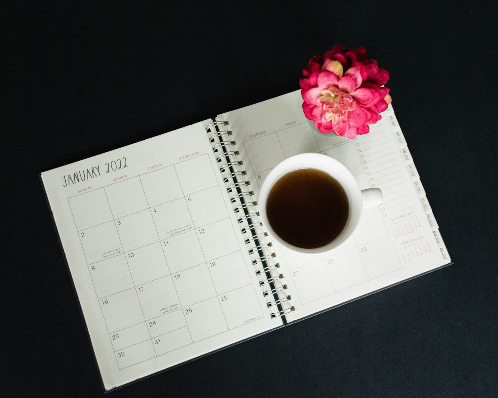 Un calendrier ouvert et une tasse de café sur un bureau