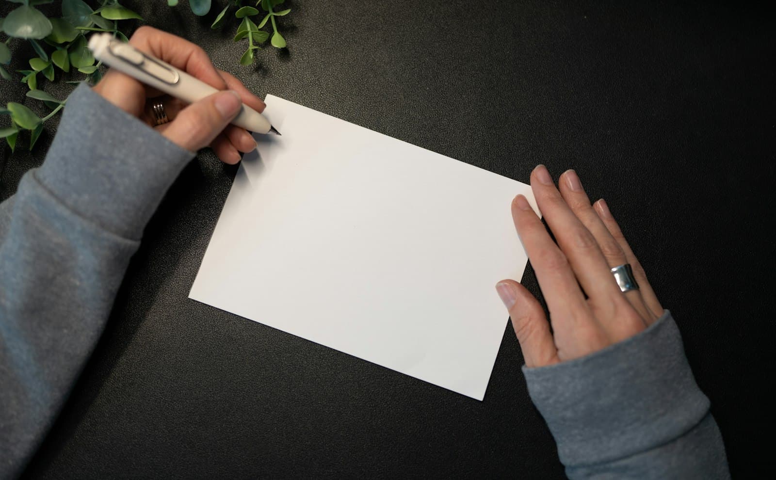 Des mains écrivent sur une carte de félicitations