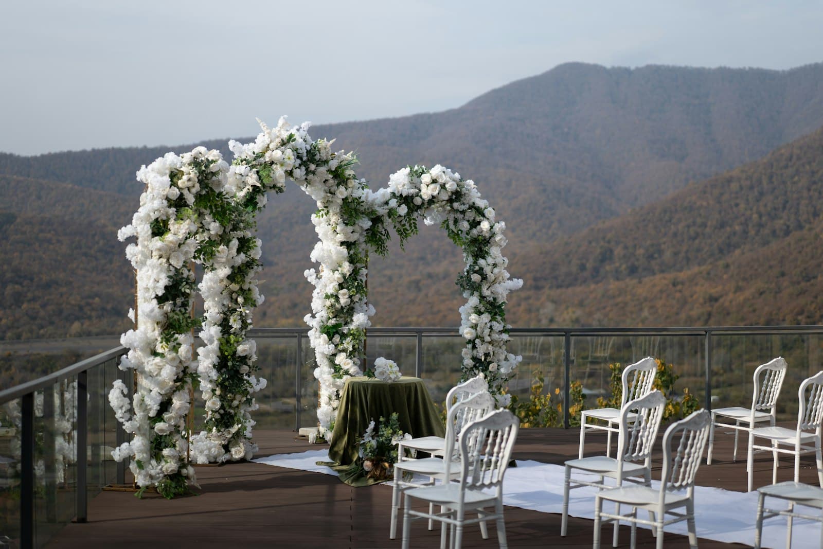 Cérémonie de mariage installée en plein air sous une arche fleurie