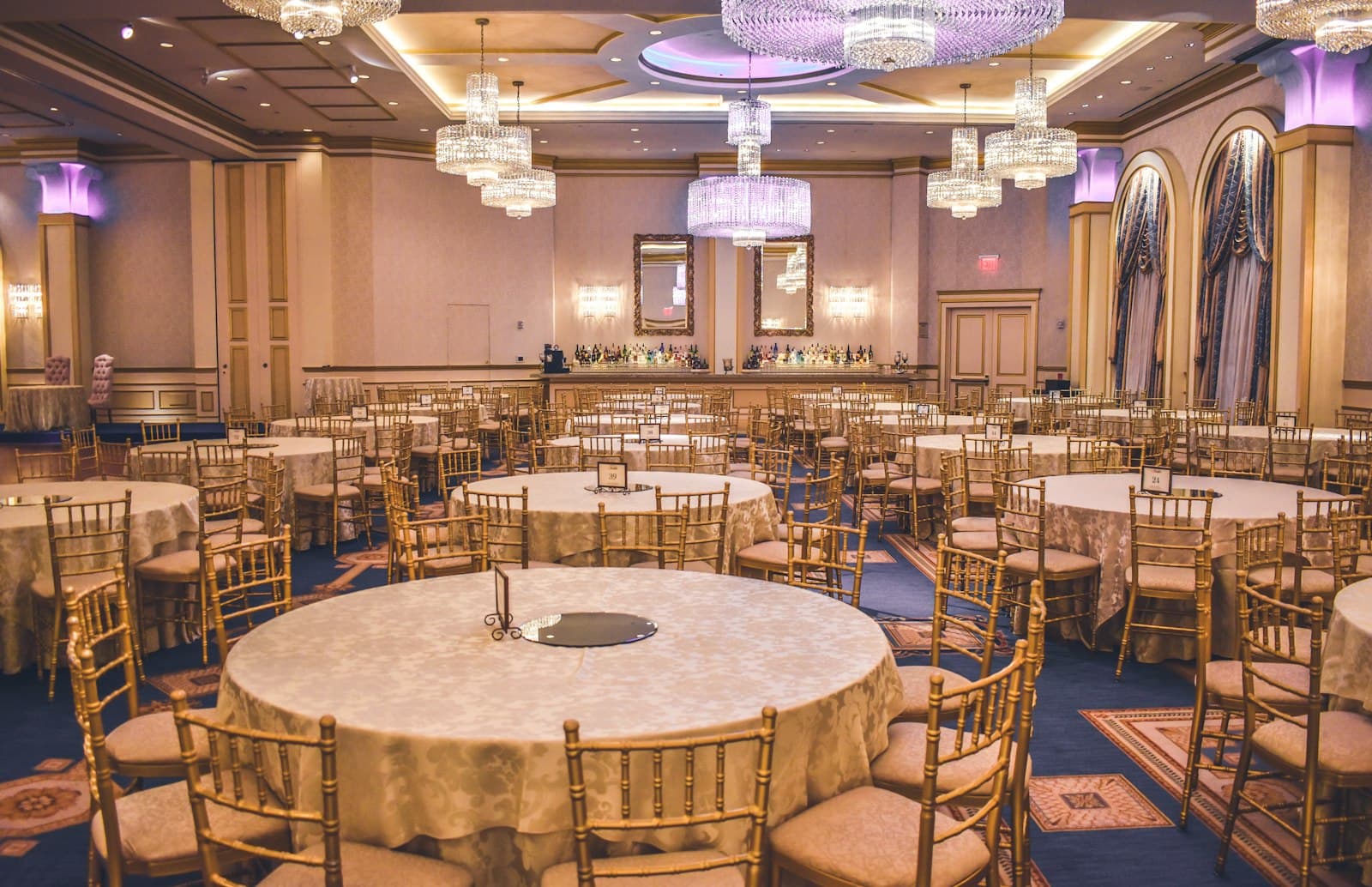 Salle de réception dressée avec tables rondes numérotées