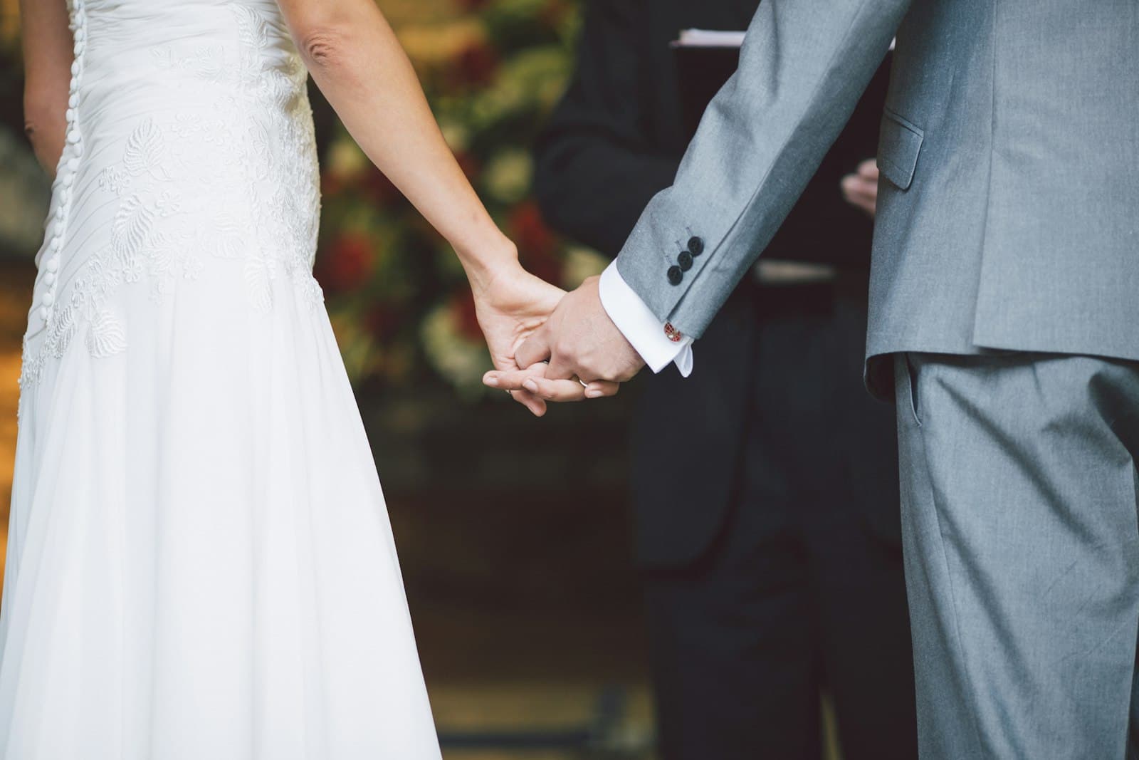 Les mariés se tiennent la main face à l’officiant pendant l’échange des vœux