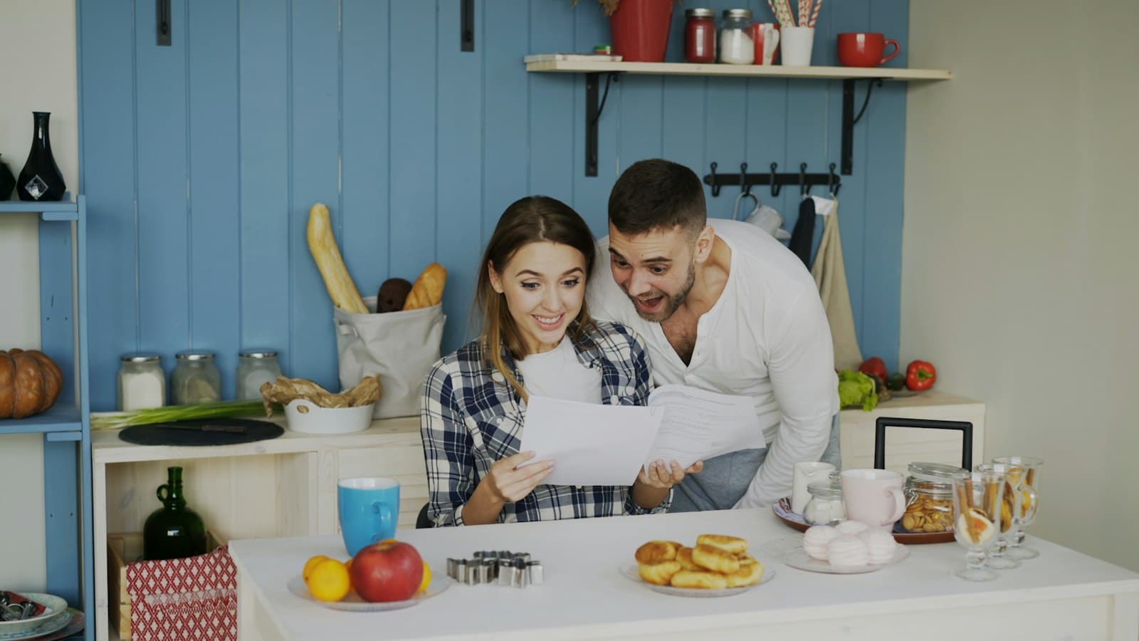 Un couple lit des documents ensemble dans sa cuisine