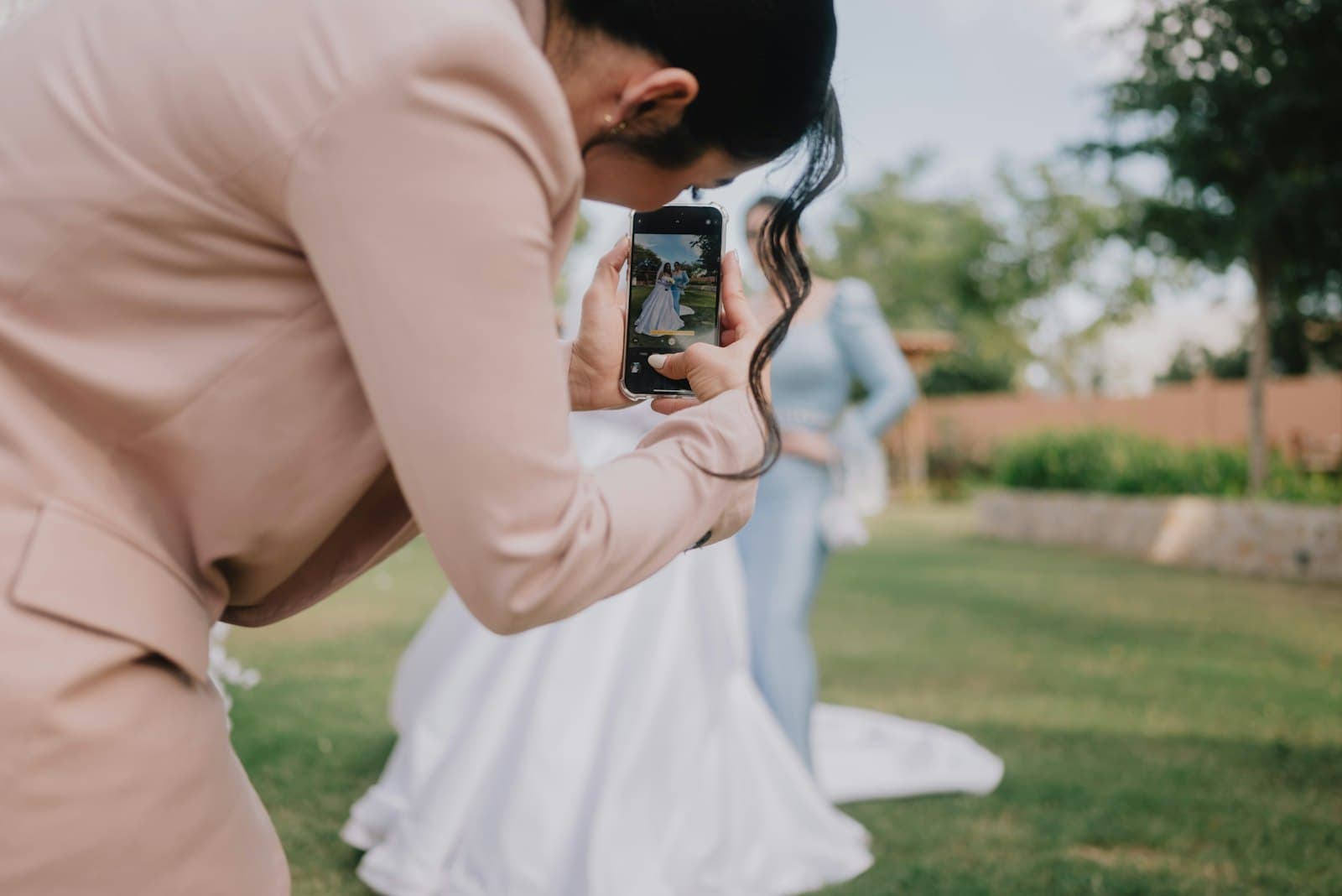 Une photographe photographie la mariée en plein air